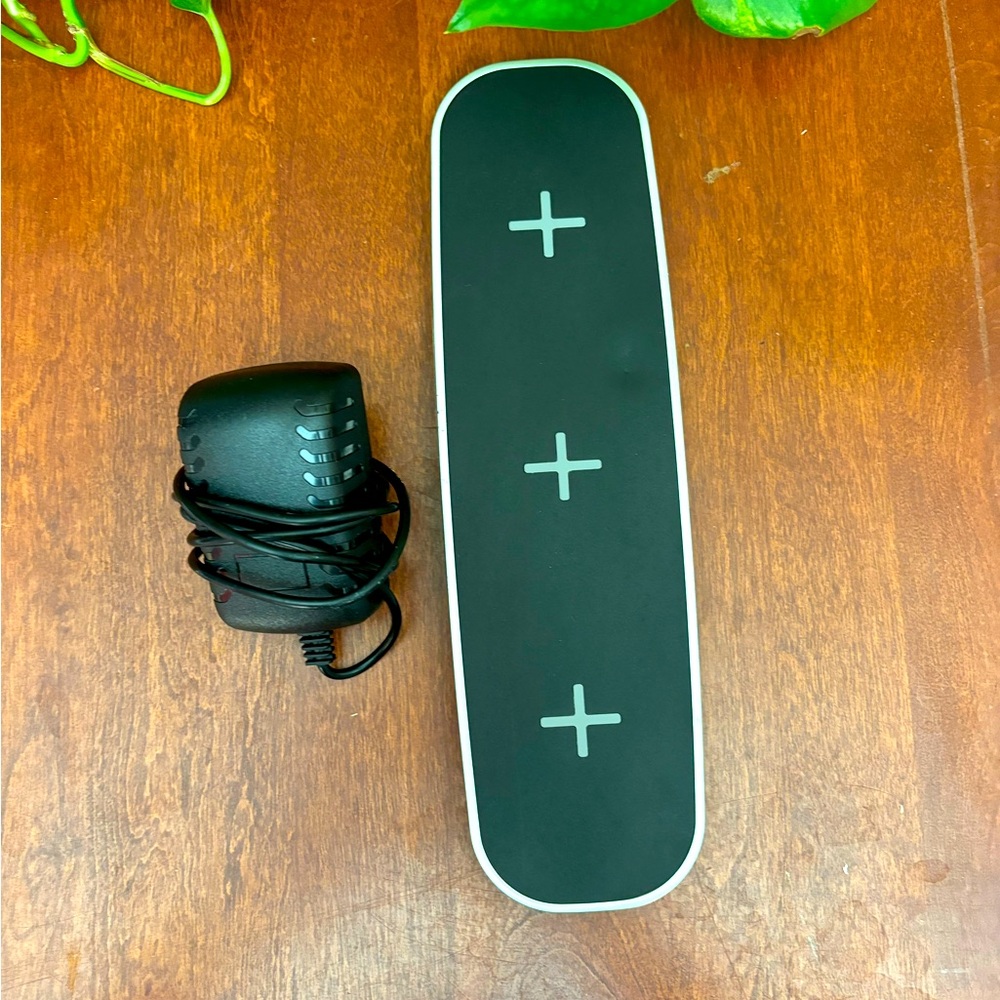 Wireless charger pad with 2 USB ports and power cord.